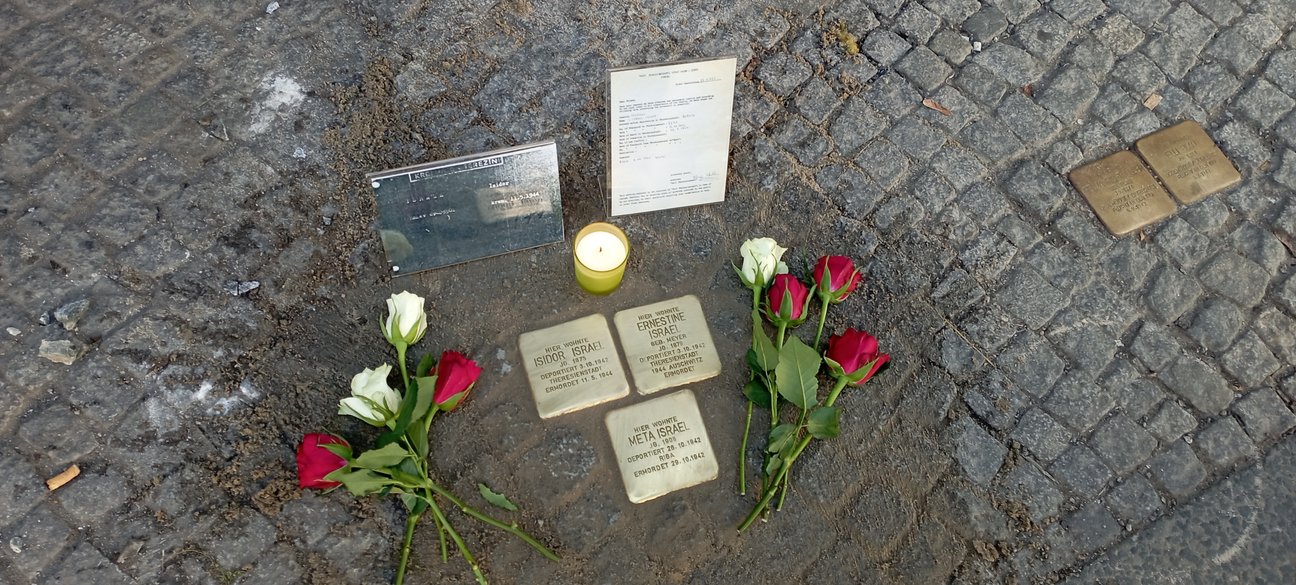 Drei Stolpersteine mit Blumen