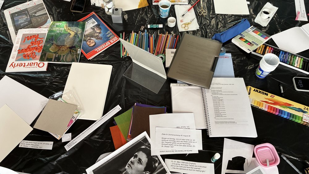 Bild eines Schreibtisches mit Buntstiften, Bastelmaterialien und Magazinen für das gestalten von Zines
