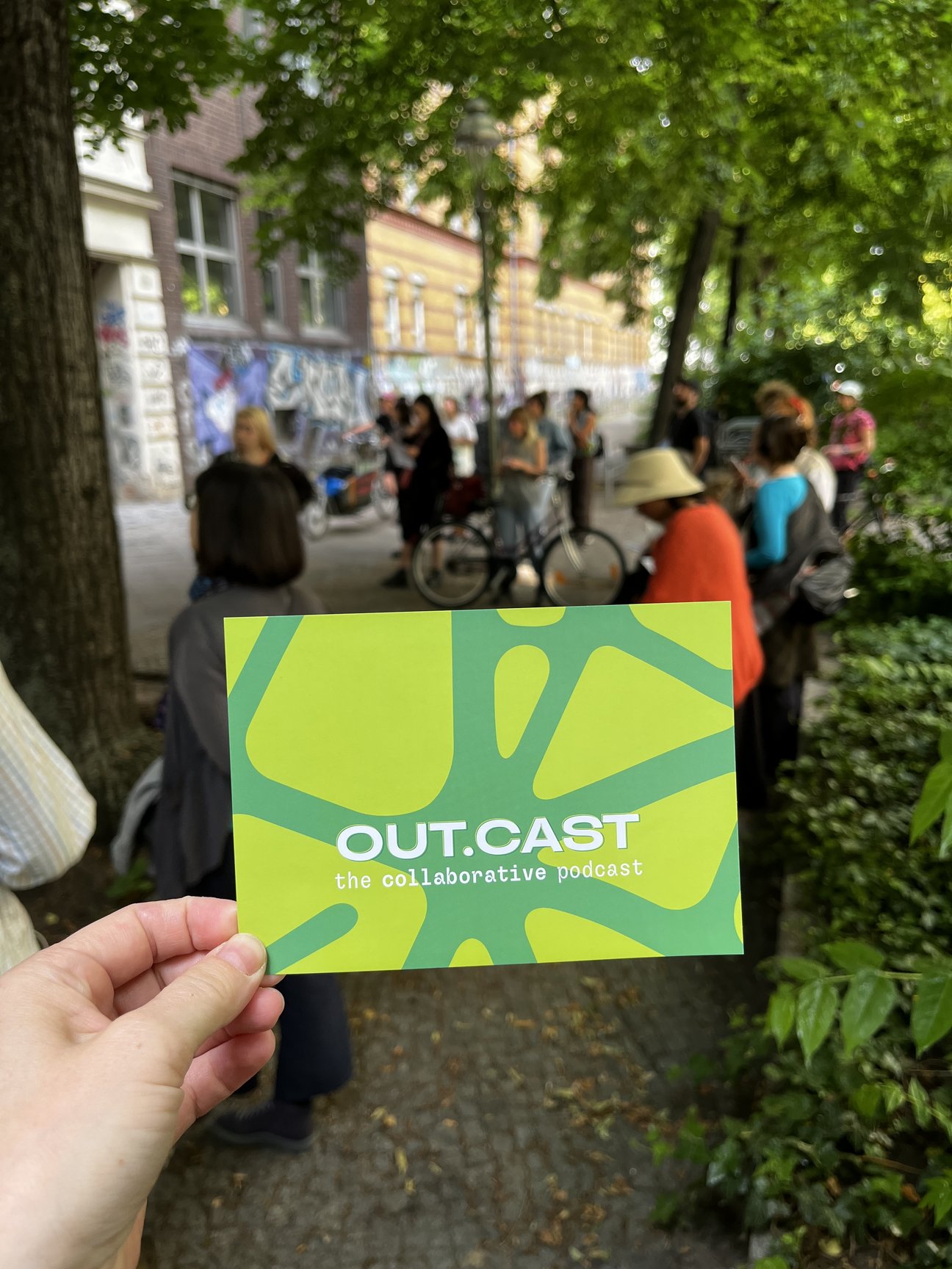 Foto eines Flyer vor Gruppe von Menschen
