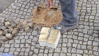 Aufnahme bei der Verlegung eines Stolpersteins im Boden