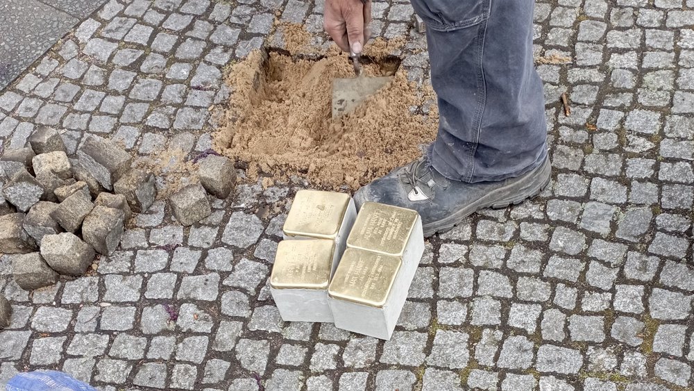 Aufnahme bei der Verlegung eines Stolpersteins im Boden