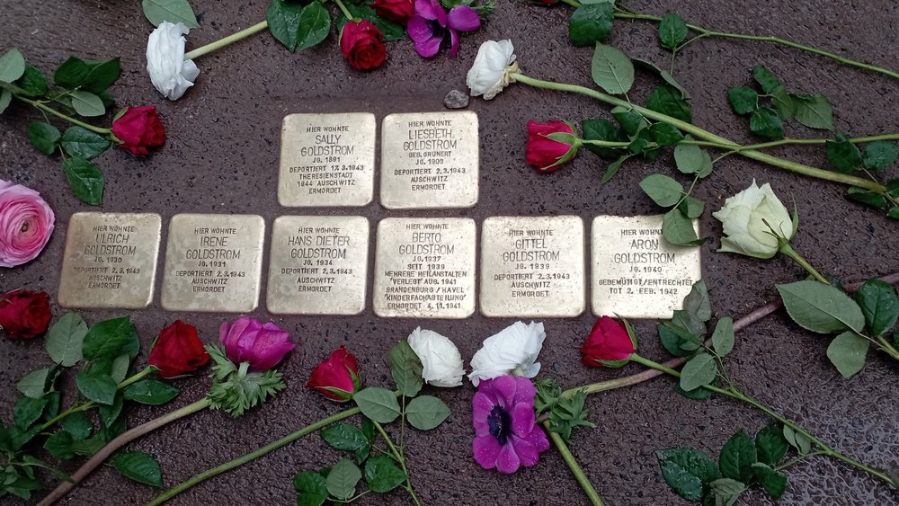 Blick auf Stolpersteine mit Blumen 