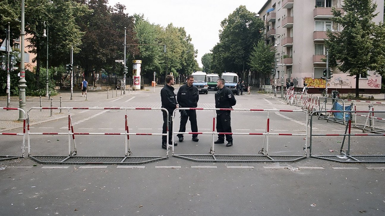 Polizisten hinter einer Absperrung